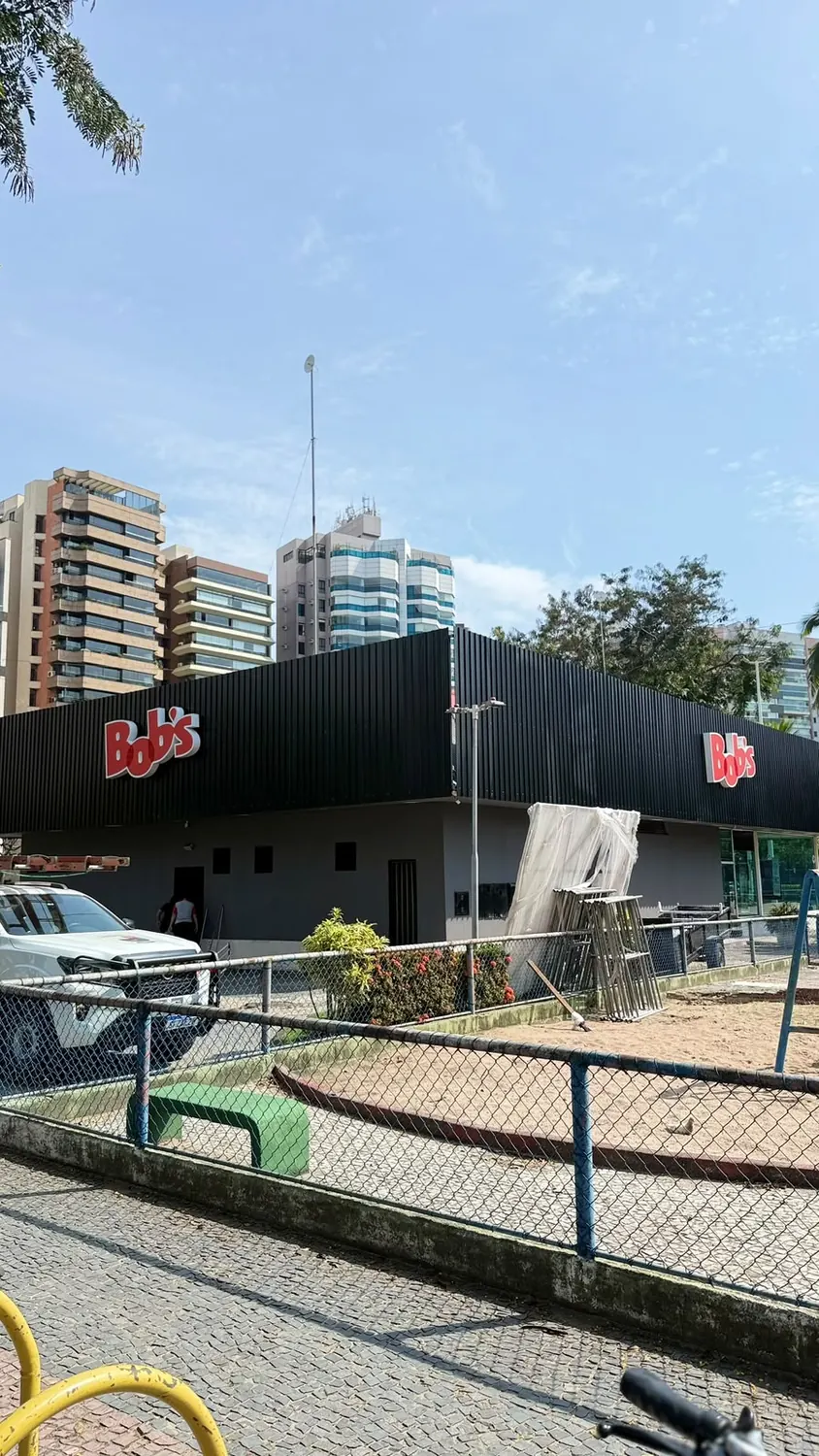 Fachada de loja Bob's em ACM preto com dois letreiros iluminados