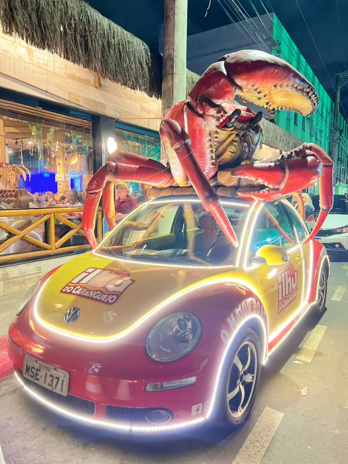 Fusca envelopado em amarelo e vermelho com caranguejo gigante no teto e fita de LED