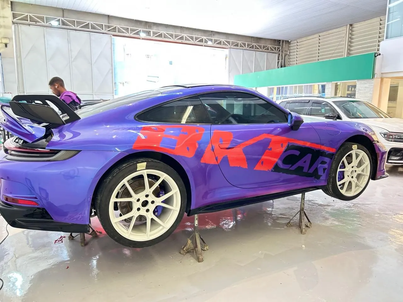 Lateral de Porsche 911 envelopado em roxo com grafismo