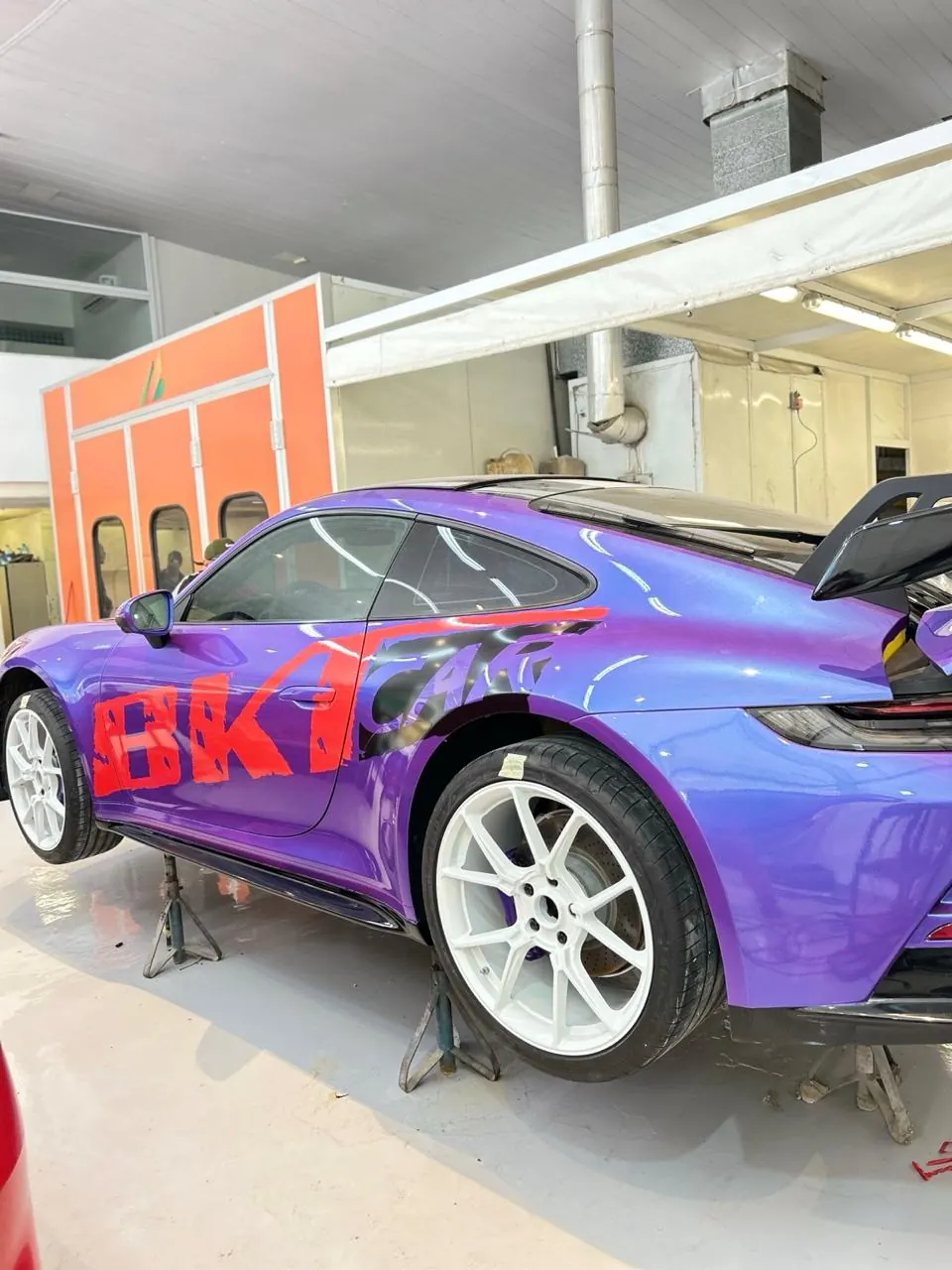 Traseira de Porsche 911 envelopado em roxo com grafismo