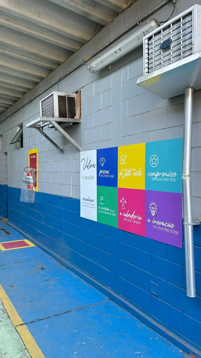 Painel colorido com os valores da empresa aplicado em parede de galpão