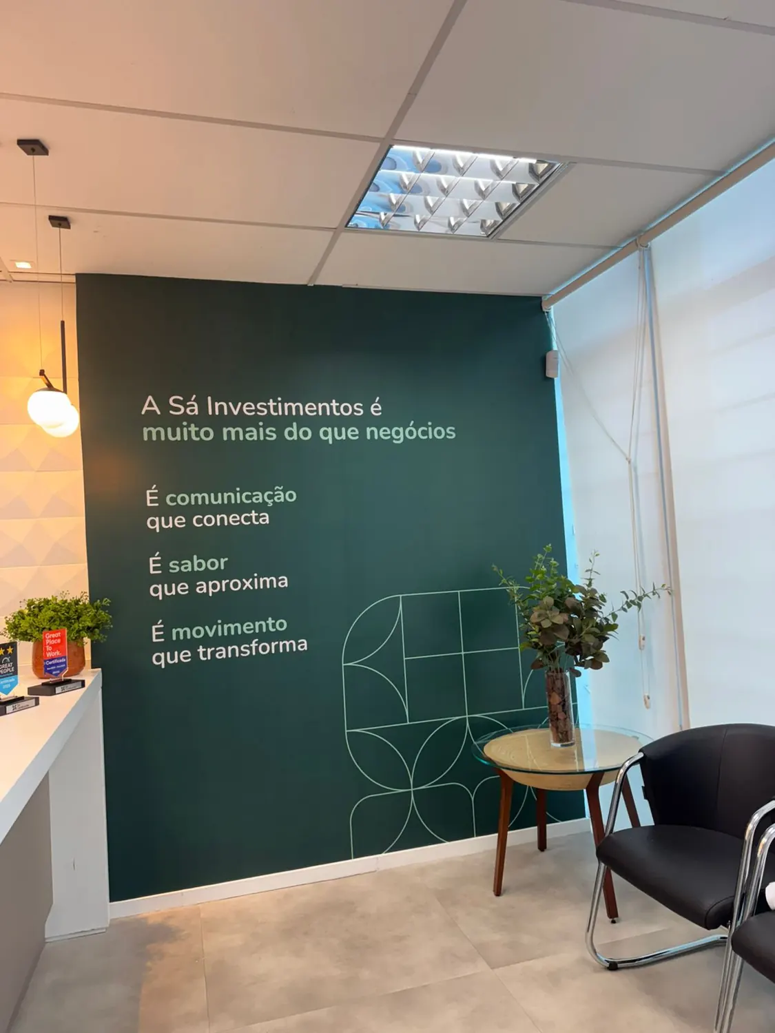 Recepção de escritório com parede verde e texto aplicado