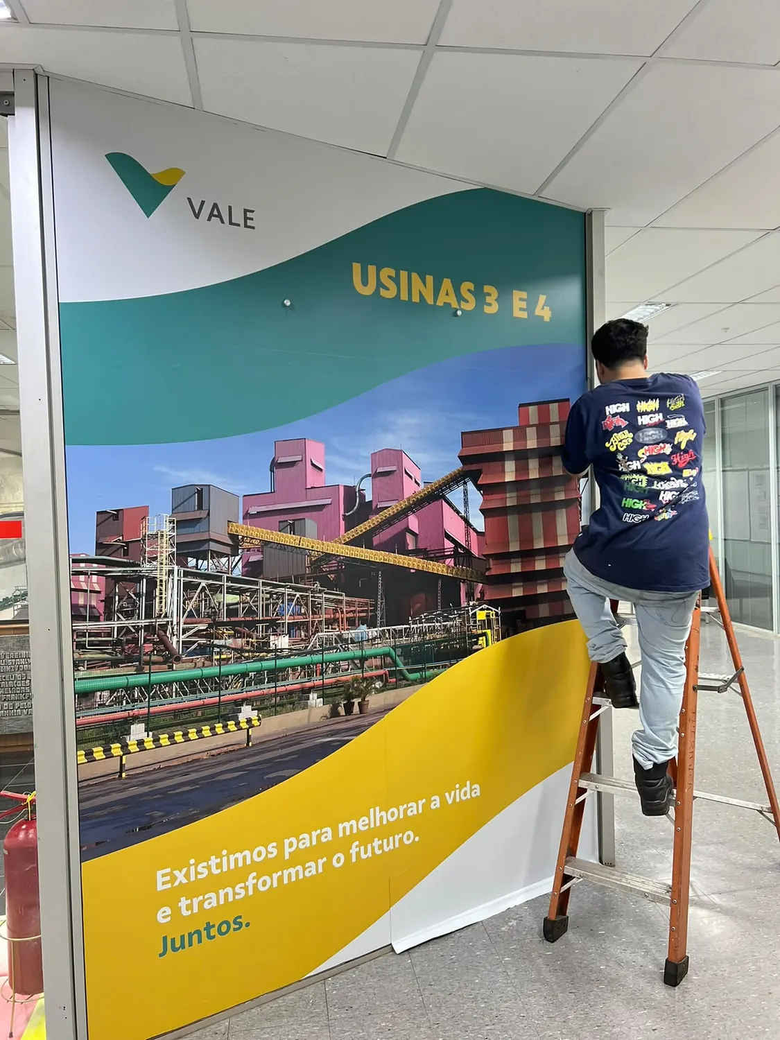 Instalador aplicando painel da Vale sobre parede em corredor